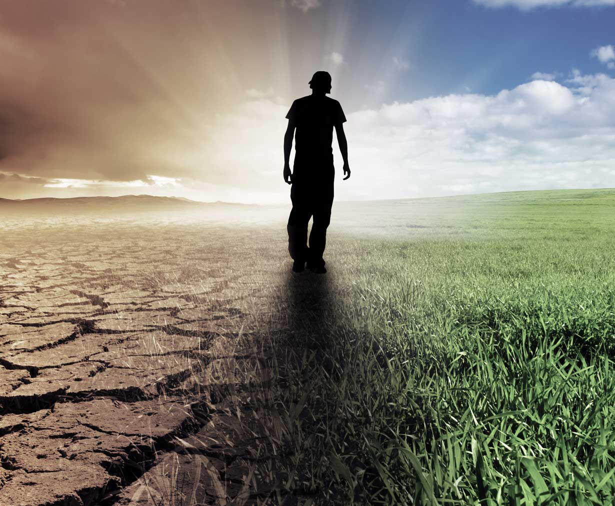 Mies kävelee pellolla, josta osa on kuivaa